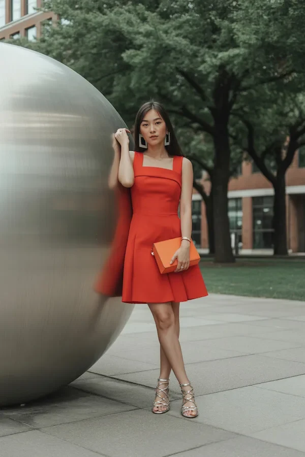 Red Fit and Flare Dress with Orange Clutch and Gold Sandals