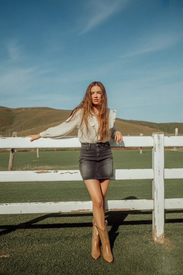 White Ruffle Blouse Black Denim Mini Skirt Tan Cowboy Boots Outfit