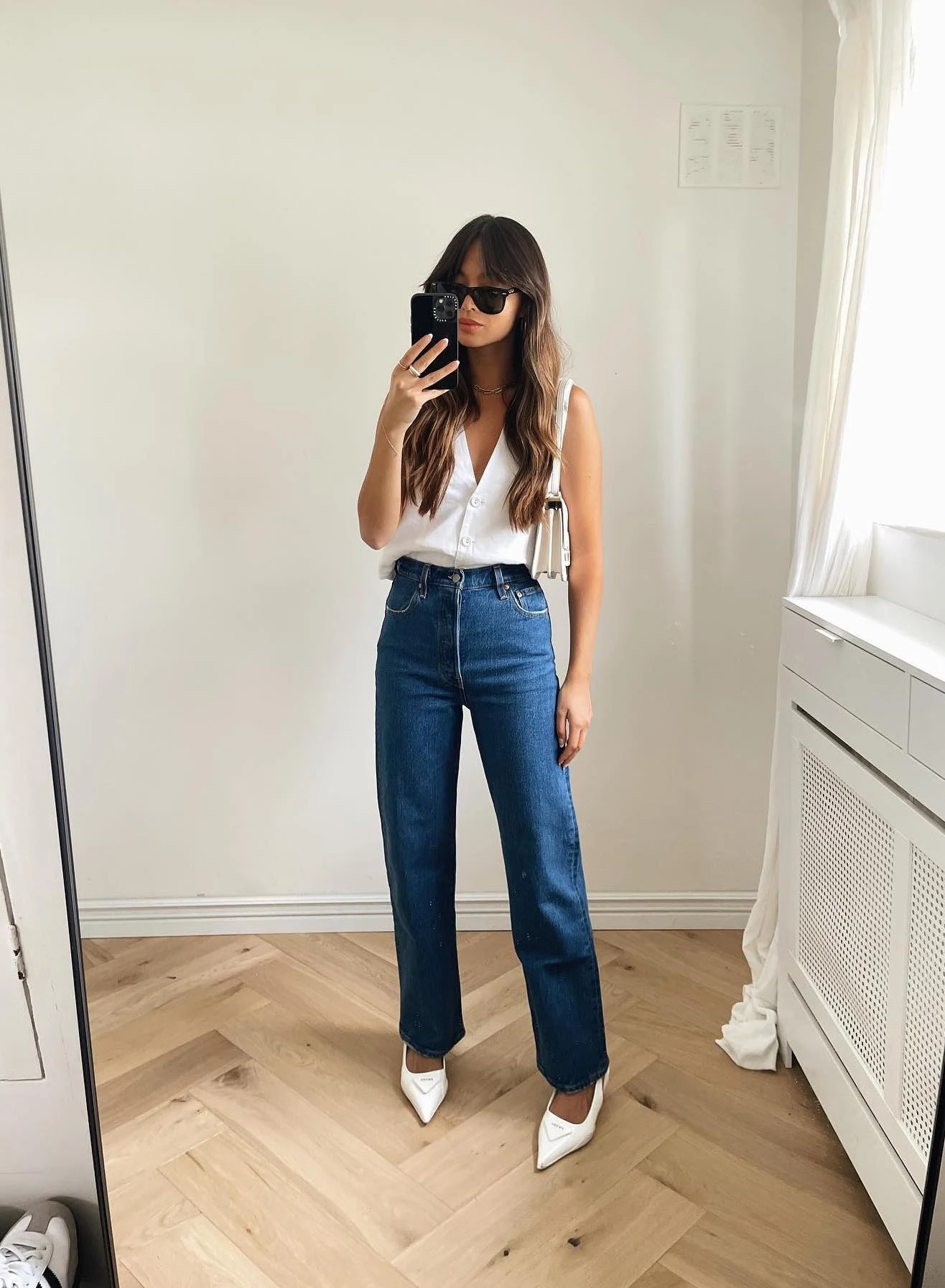 White Sleeveless Shirt High-Waisted Jeans White Heels Outfit